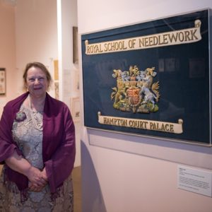 Dr Susan Kay-Williams posing with royal school of needlework logo