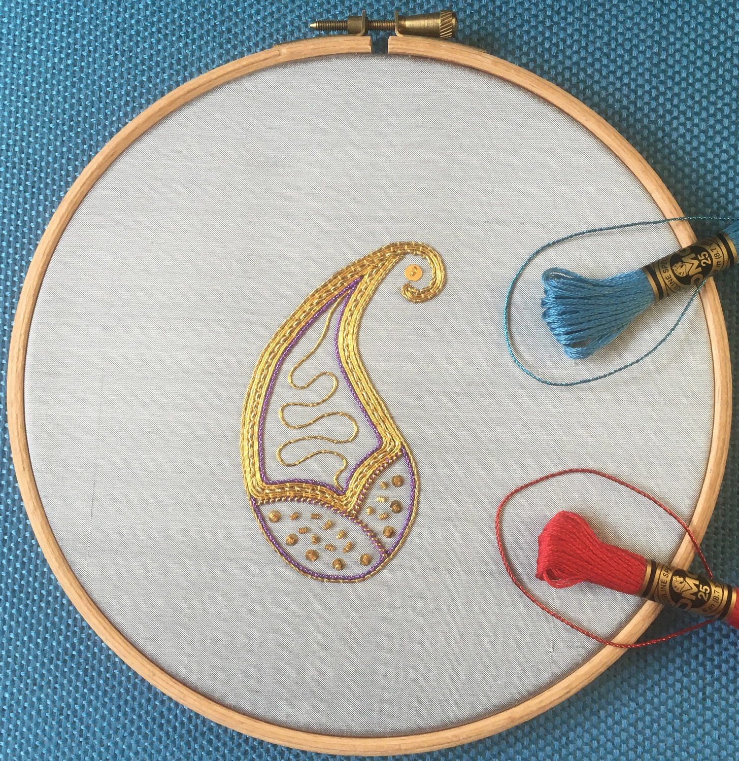 HCP23065 NF Golden Paisley 3 1500px Golden paisley finished piece with blue and red thread