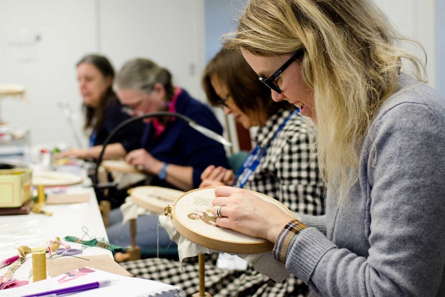 A group of women stitching using hoops.